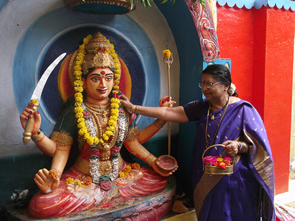 Lady at a Temple with Flower Basket with handle performing Pooja to Goddess.