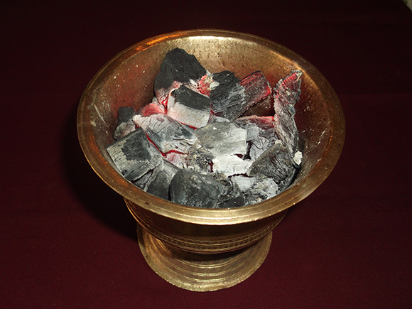 Sambrani brass pot with charcoal fire.