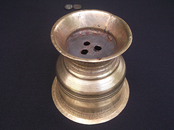 Upside down view of sambrani brass pot.
