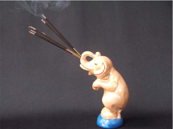 Elephant holding burning incense sticks