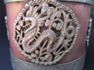 The embellishment of single dragon surrounded by intricate design forming a round shape