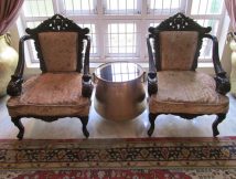 Two old Portuguese  chairs restored .One old brass vessel with glass top positioned as tea table, Two huge brass Gangalams serve as curtain holders
